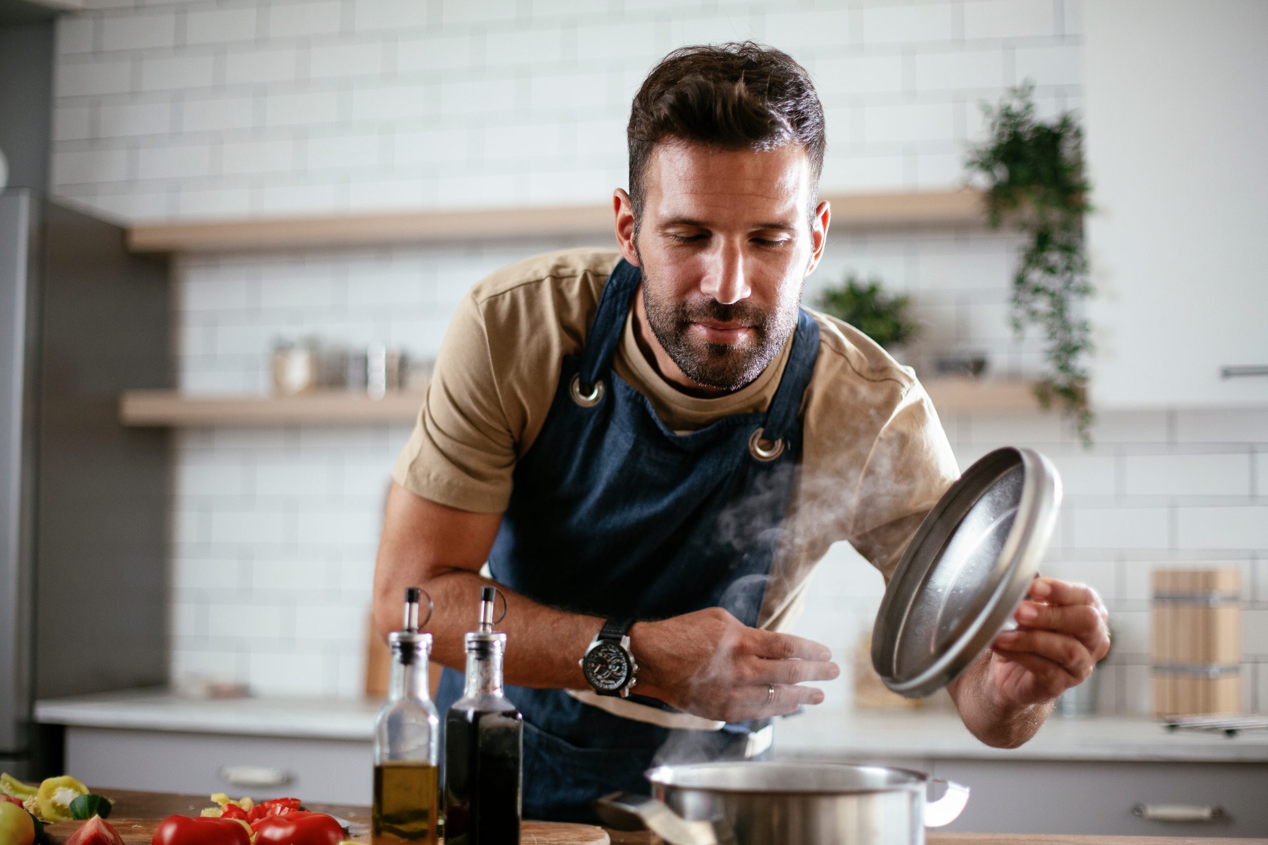 Young man cooking dinner with pot on stovetop