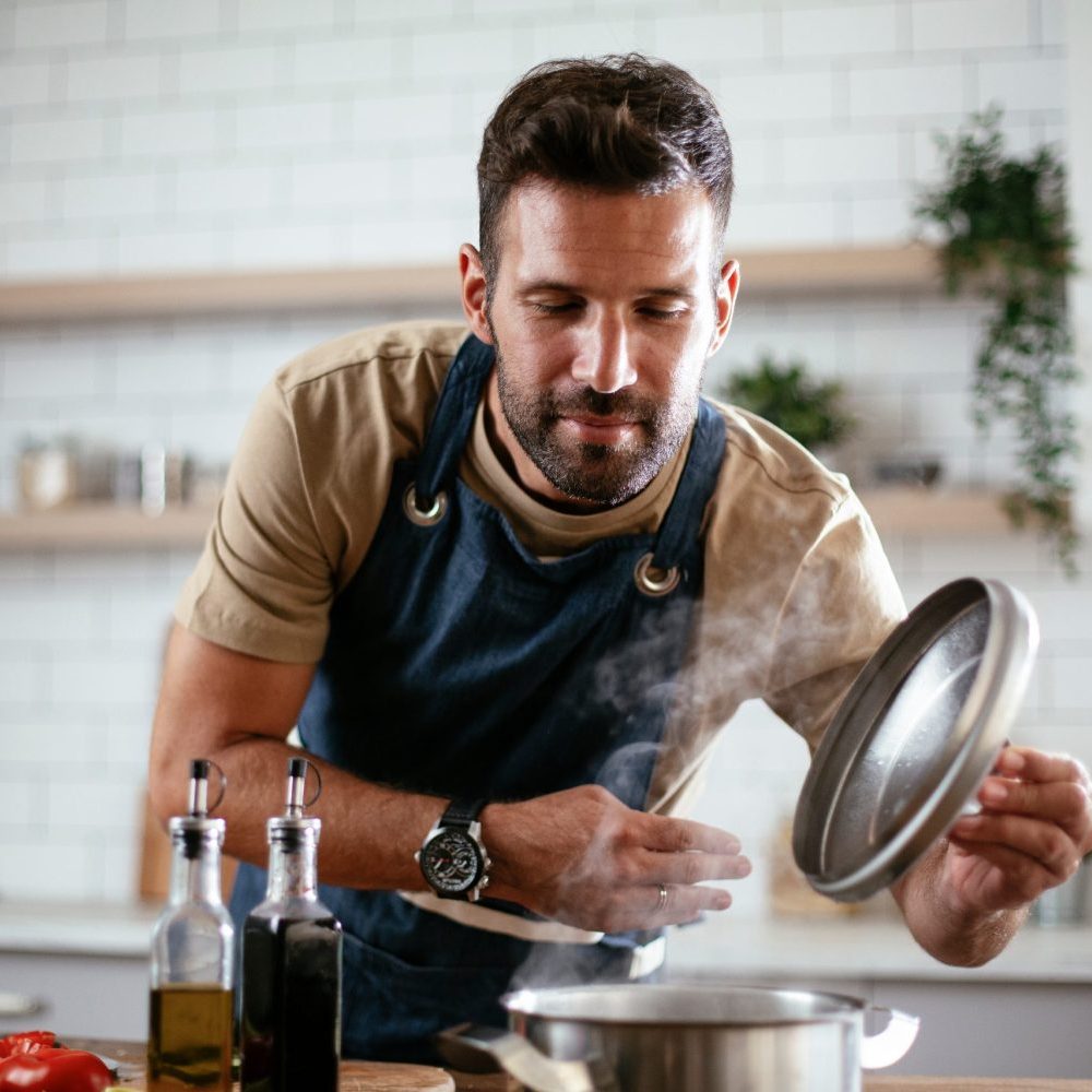 Happy Man Cooking in Kitchen