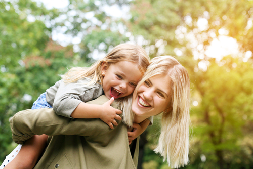 Millennial mom with Gen Alpha daughter on her back.