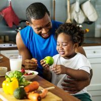Father eating healthy food with child