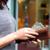 woman pulling dollar bills out of wallet