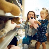 Mom,And,Little,Girl,Choosing,Soft,Toys,,Kid's,Shop