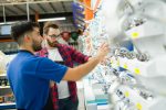 Rear,View,Of,A,Male,Employee,And,A,Customer,Talking Home improvement product line review of faucets