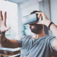 Young,Bearded,Man,Wearing,Virtual,Reality,Glasses,In,Modern,Interior Young,Bearded,Man,Wearing,Virtual,Reality,Glasses,In,Modern,Interior